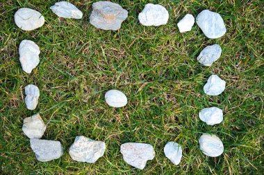 Çayırın ortasında taş yumurta bulunan desenli taşlardan yapılmış dikdörtgen çerçeve - arka plan