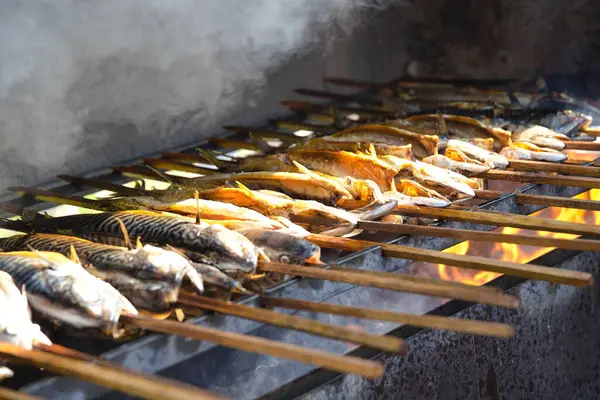 stock image Fresh fish pikeperch and trout are smoked - smoked fish on a skewer