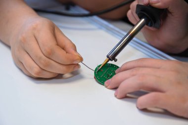 Elektronik bileşenleri lehimleyen elektrik mühendisi - yakın çekim teknolojisi