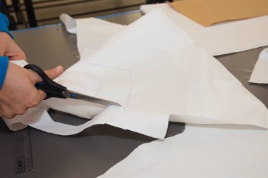 Craftsman with scissors during textile processing - tailoring close-up