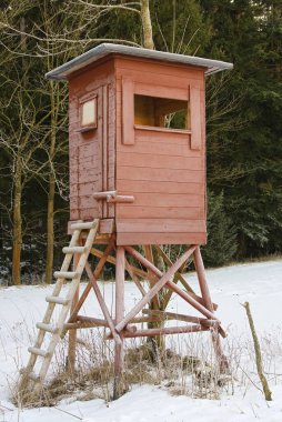 Kışın yüksek kahverengi ahşap ayaklık - avcılar için saklanma yeri olarak yüksek koltuk