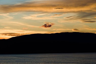 Deniz kenarında romantik günbatımı - sarı-turuncu bulut oluşumu, doğal güzellik