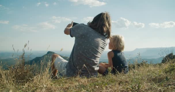 가족은 여행을 아름다운 풍경으로 아이와 꼭대기에 경관을 즐긴다 — 비디오
