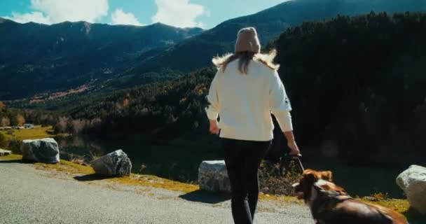 Kobieta Biegnie Trzymając Swojego Zwierzaka Smyczy Drogi Górskiej Wskoczyć Skały — Wideo stockowe
