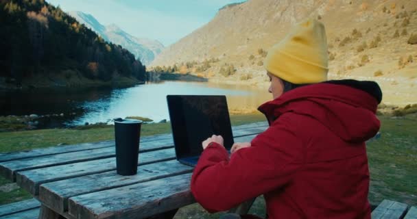 Wolny Strzelec Siedzi Pięknym Górskim Krajobrazie Przy Użyciu Laptopa Pije — Wideo stockowe