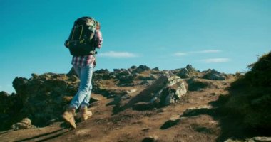 Turist sırt çantasıyla dağ tırmanışı yapan bir kadın. Dişi turist seyahatte dağ yolunda yürüyor. 