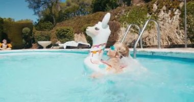 Yaz tatilinde neşeli çocuk şişme yüzükle havuza atlıyor..
