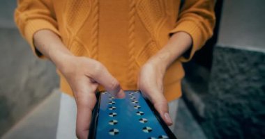 Woman walk on city street using smartphone device hands closeup