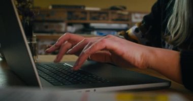 Closeup freelance woman hands typing on laptop computer keyboard on evening working at home