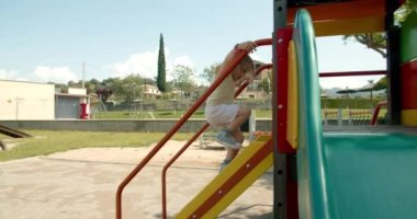 Mutlu kız çocuğunun yavaş çekim sahnesi yaz vakti oyun parkında kayıyor ve gülümsüyor.