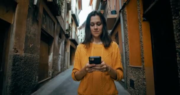 Atrakcyjna Wesoła Kobieta Spaceruje Ulicą Starego Miasta Telefonem Komórkowym Rozmawiając — Wideo stockowe