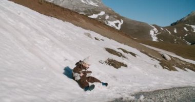Dağ yolculuğu macerasında kayan neşeli çocuğun yavaş çekimleri.