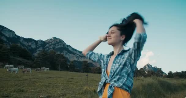Wesoła Kobieta Naprawia Włosy Wakacyjnej Wycieczce Spacer Łące Pastwiskowej Górach — Wideo stockowe