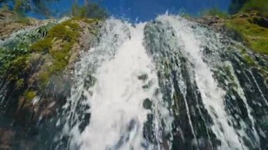 Şelale damlacıkları kamera merceğine düşer. Dağ şelalesinde akan suya aşırı yakın çekim. Doğal ortamda güzel nehir yavaş çekim. 