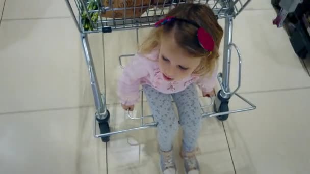 Zakupy Dziećmi Siedzieć Wózku Supermarketu Ruchu Maluch Dziewczyna Rodzicami Sklepie — Wideo stockowe