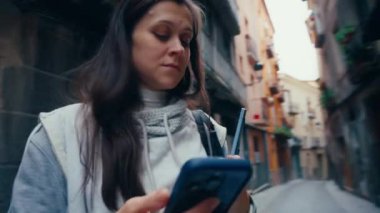 Dizüstü bilgisayarı ve akıllı telefonu olan bir kadın şehir caddesinde yürüyor. Kablosuz teknolojisi olan insanlar.. 