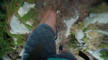 Yukarıdan aşağıya doğru çekim, yolda yürüyüş yapan ve dağa tırmanan adam. Yürüyüş macerasında yürüyen kişinin kişisel perspektifi. 