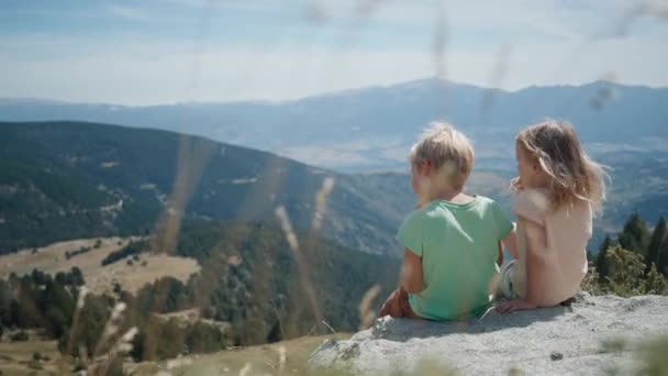 아이는 아름다운 풍경을 수있는 언덕에 여행에 간식을 형제와 자매는 산길에 — 비디오