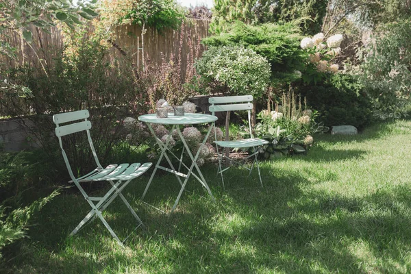 Klidný Útulný Zahradní Kout Pastelovým Mátovým Stolem Židlemi Bílými Květy Stock Snímky