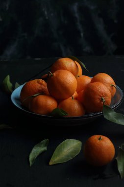 Siyah arkaplanda bir grup mandalina