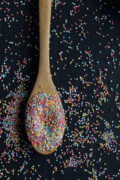 Cukor Sprinkles Egy Kanál Egy Fekete Háttér — Stock Fotó