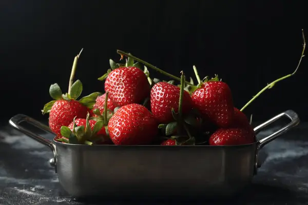 黑色背景的草莓 金属碗里的草莓 图库图片