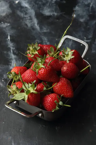 Erdbeeren Auf Schwarzem Hintergrund Erdbeeren Einer Metallschüssel lizenzfreie Stockfotos