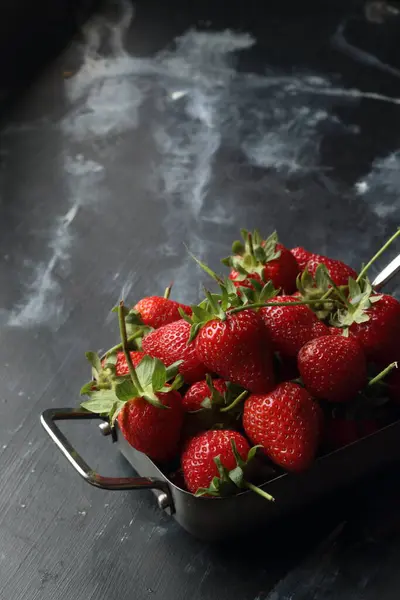 黑色背景的草莓 金属碗里的草莓 免版税图库图片