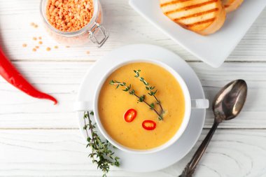 Fresh red lentil soup puree on a wooden table. View from above.