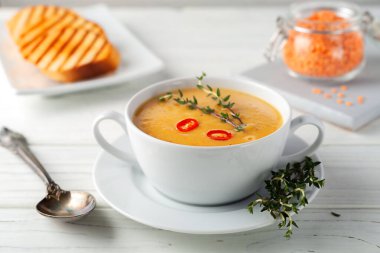 Fresh red lentil soup puree on a wooden table. View from above.