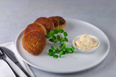 Beyaz tabakta mayonezli lezzetli balık kekleri..