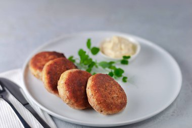 Beyaz tabakta mayonezli lezzetli balık kekleri..