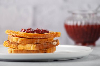 Reçelli kızarmış ekmek ve ahşap bir masada bir fincan sıcak kahve. Avrupa kahvaltısı.