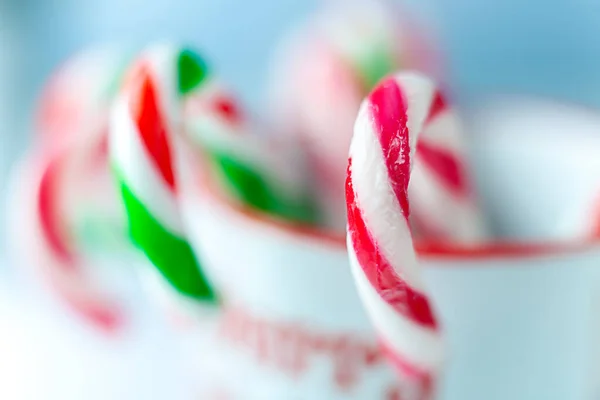 Red-white and red-green Christmas caramel in a cup. Christmas background.