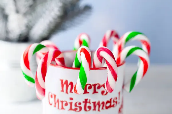 Red-white and red-green Christmas caramel in a cup. Christmas background.