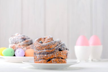 Hamur hamuru. Kek şeklinde kruvasanlar. Hafif ahşap zemin üzerine pudra şekeri serpiştirilmiş..