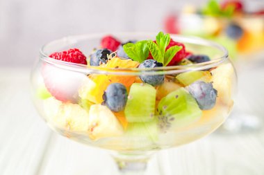 Hafif ahşap bir masa arkasında nefis diyet taze meyve salatası.