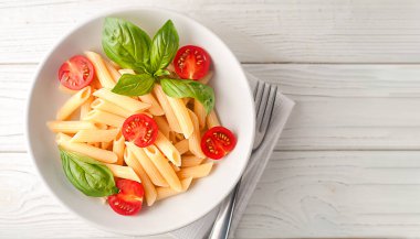 Tahta bir tabakta fesleğen aromalı lezzetli bir makarna. Üst görünüm.