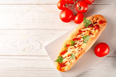 Baget - sosisli sandviç ve izole edilmiş beyaz arka planda taze sebzeler. Amerikan fast food.