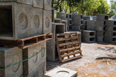 Barselona, İspanya 'da yeni bir kentleşme projesi için kullanılmak üzere, bir inşaat alanındaki ahşap paletlere istiflenmiş önceden yapılmış beton rögar kapakları görüntüsü