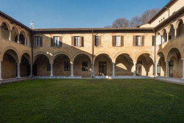 Güneş ışığı, Brescia 'daki Santissimo Corpo di Cristo Kilisesi' ne bağlı manastır manastırını aydınlatır. Alt kat mermer sütunlar ve çapraz kasalarla kaplı yuvarlak kemerler ile karakterize edilir..