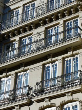 Elegant classy building with windows and balconies with stucco decorative elements in the central district of Madrid, Spain.