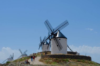 Campo de Criptana, Toledo, Spain - June 12, 2021: authentic windmills under the blue sky in the popular weekend trip destination clipart