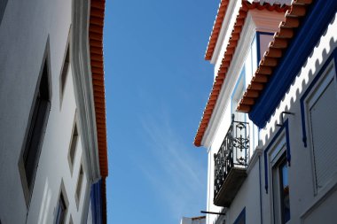 Looking up on authentic white houses in narrow street of typical Portuguese village in Arronches, Portugal.