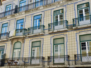 Tiled vintage facade with elegant windows and balconies downtown in Lisbon, Portugal.