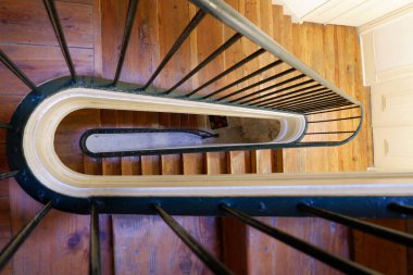 Vintage wooden staircase in the classical building in Lisbon, Portugal Winding old stairs. Looking down.