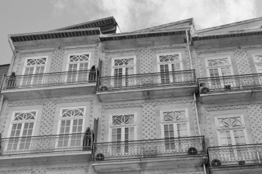 Classical buildings with balconies windows and facade decorated with traditional blue tiles downtown Porto, Portugal. Black and white photo.