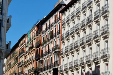 Madrid, İspanya 'nın merkezinde pencere ve balkonları olan renkli klasik klasik binalar..