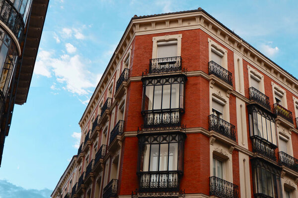 Classy vintage buildings with elegant black metallic balconies in the center of Madrid, Chueca district, Spain.