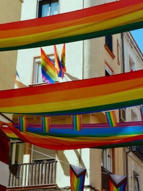 Madrid sokaklarında sallanan ve sallanan gay bayrakları. Eşcinsel Onur Günü 'nde eşitlik sembolünün dikey fotoğrafı.